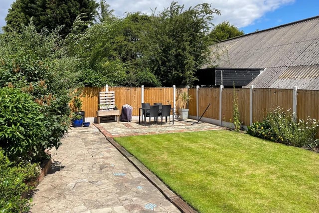 The back garden has a well-maintained lawn, a charming patio area and secure fenced boundaries, providing privacy and security.