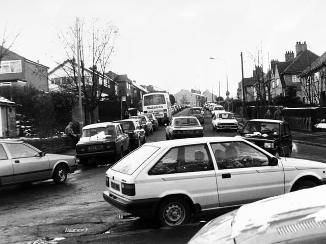 The chaotic scene at the end of the school day at Pudsey Fartownin November 1988. Traffic builds up and vehicles park waiting to pick up pupils from Fulneck School.