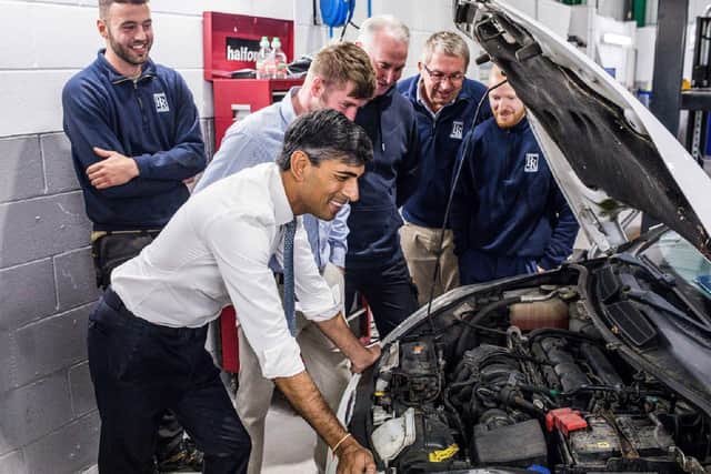 Rishi Sunak chats with technicians during an inspection of the workshop facilities
