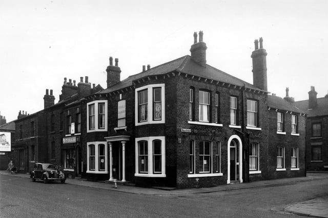 The Prince of Wales pub on South Accommodation Road. To the left of this is a small grocers, Booth's, with a car parked outside. On the right is Holm Street. Pictured in August 1958.