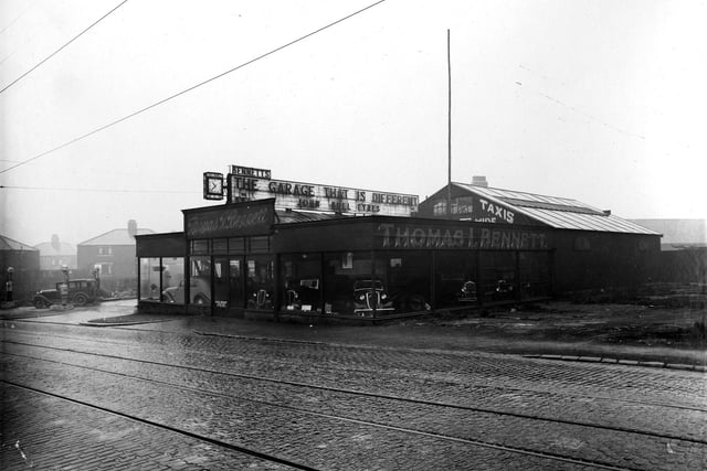 Thomas I. Bennett Ltd, garage and petrol retailer on Stanningley Road in January 1937. The image shows the car showroom with cars displayed for sale behind the glass.