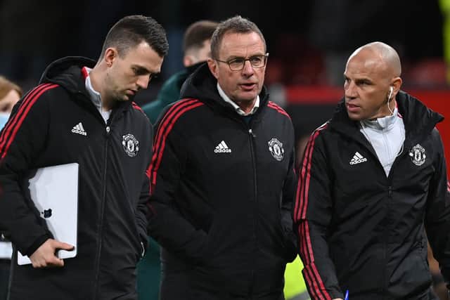 Manchester United German Interim head coach Ralf Rangnick (C) speaks with Manchester United's assistant coach and analyst Ewan Sharp (L) and Manchester United's US assistant coach Chris Armas (R) during their spell at Old Trafford (Photo by PAUL ELLIS/AFP via Getty Images)