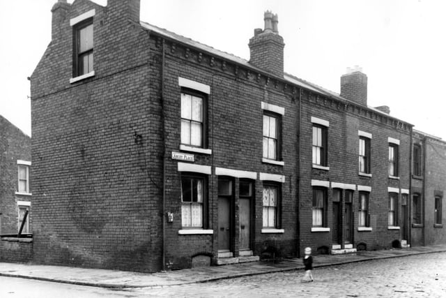 Back-to-back terraces, on the left of the building a plaques notes the location of a fire hydrant, while on the right the empty windows of the derelict number 11 property is visible. A small boy is walking along the street. Pictured in October 1966.