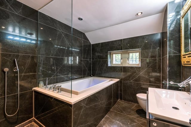 The family bathroom features wall to ceiling tiling along with a bath and separate shower.