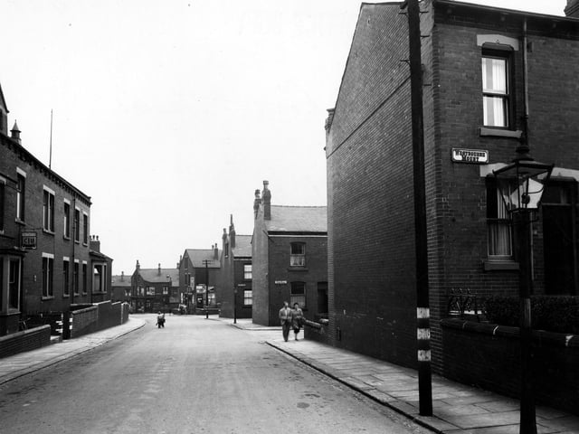 Looking east along Rowland Road in August 1949. On the right a gas street lamp is prominent. Behind it are the junctions with Westbourne Mount, Bude Road and Clovelly Row. A telephone pole with blackout markings and two people are on the pavement. On the left, number 36/38 is Rowlands Road Working Men's Club & Institute. Two children play in the road.