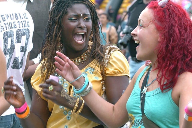 Leeds Mela at Roundhay Park in August 2005. Pictured are two young ladies in the crowd dancing to the music.
