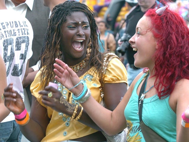 Leeds Mela at Roundhay Park in August 2005. Pictured are two young ladies in the crowd dancing to the music.