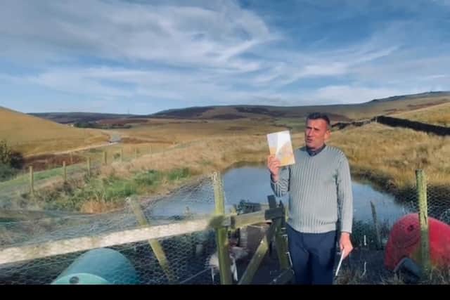 Richard showing his book in front of the setting for ‘Calm Pond’