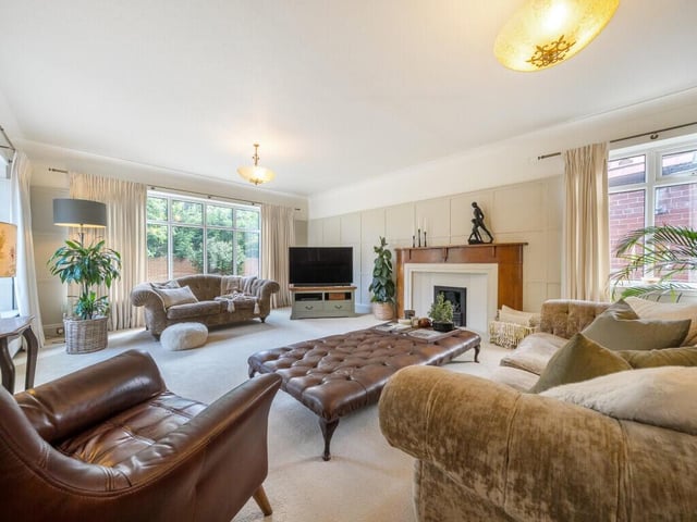 To the rear of the home, there is a formal living room, with large windows that overlook the private garden.
