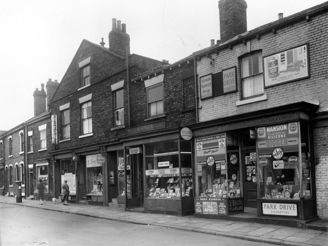 Shops in Hillidge Road in July 1961. A pillar box stands outside Hillidge Road Post Office, then a fish and chip shop, then E. Sugden, radio, television and electrical dealer. Next is A. Senior, dispensing chemist and far right, W. Hawley, Newsagents and tobacconist.