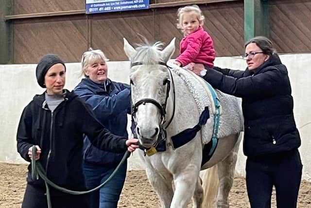 Paige enjoying a hippotherapy session - which involves physiotherapy on horseback.