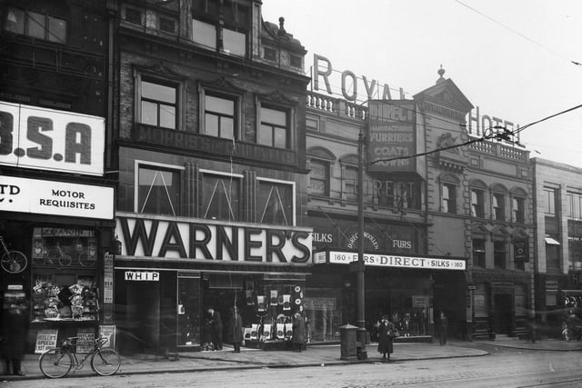 Shops on Briggate in March 1936. Pictured, from left to right, are Watson Cairns, Direct Woollen Co, Royal Hotel, Lamberts Chambers. The entrance to Bowers Yard and Whip Public House can also be seen.
