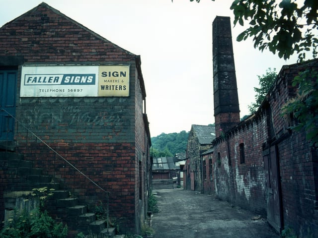 The derelict buildings of Woodlands Dyeworks on Wood Lane pictured in July 1975 shortly before demolition. Known as Crowther's Mill and previously Rowley's Mill and Wood's Mill, there is believed to have been a mill on the site since 1601. The building in the foreground here was also more recently occupied by Faller Signs, sign makers and writers. In 1974 Leeds City Council took over the site and the mill was subsequently demolished.
