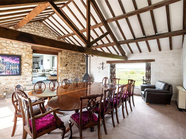 Double doors open through into a separate dining room which offers full height vaulted ceilings which presents exposed beams and trusses.