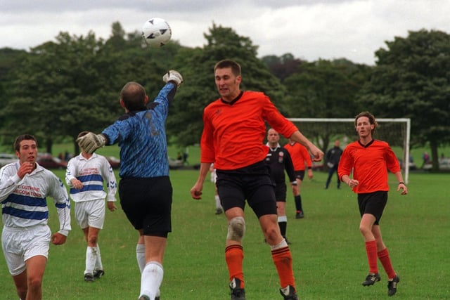 Match action from the Leeds Sunday League clash between Oakwood Athletic and Woodies in September 1997.  Woodies goalkeeper Berni Gilmore pinches the ball clear of Oakwood Athletic striker Chris Best.