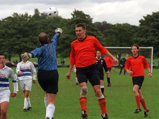 Match action from the Leeds Sunday League clash between Oakwood Athletic and Woodies in September 1997. Woodies goalkeeper Berni Gilmore pinches the ball clear of Oakwood Athletic striker Chris Best.
