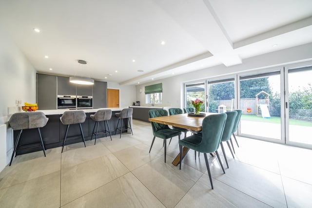 The kitchen enjoys a range of wall and base units finished with a handleless design and undercounter lighting, accompanied with Quartz worktops and integral appliances. The space is open-plan with ample space for a dining table and a separate seating area, all finished with a stylish tiled floor.