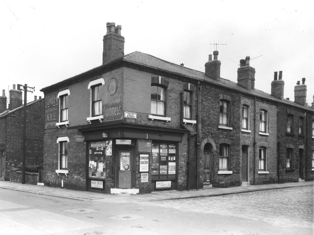 The corner shop pictured in July 1961 is on Beza Street, selling drinks, groceries and tobacco. Tulip Street is running off to the right.