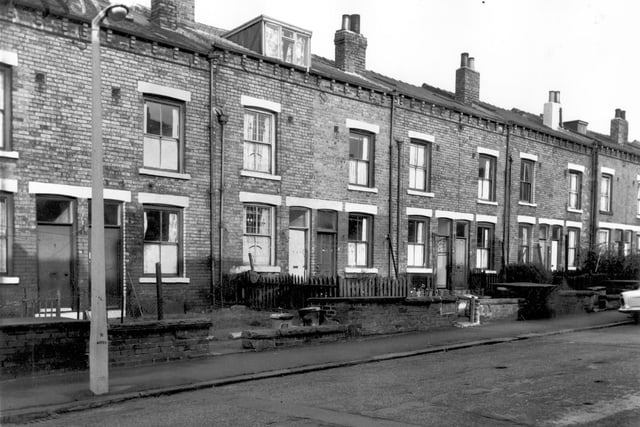The rear entrances and gardens of through terraces fronting onto Ascot Avenue in October 1966. Each house has a private garden with most containing a washing line, dustbins, or the occasional plant. A dormer window has been added to number 90 whose lower windows retain their original leaded glazing.