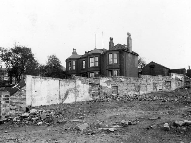 A view of waste ground on Armley Road in September 1937, showing where houses have been demolished. The area was known locally as the Maltkins. Behind a long wall can be seen a large house. This was Wellgarth House, 161 Armley Road, and was the home of Archibald Haddow, physician and surgeon, and James Haddow, dental surgeon. 