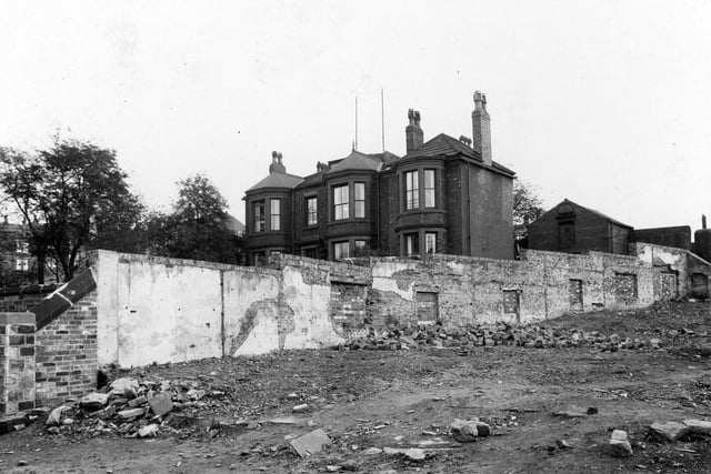 A view of waste ground on Armley Road in September 1937, showing where houses have been demolished. The area was known locally as the Maltkins. Behind a long wall can be seen a large house. This was Wellgarth House, 161 Armley Road, and was the home of Archibald Haddow, physician and surgeon, and James Haddow, dental surgeon. Dr. Archibald Haddow was a very well known General Practioner in the area. Along with his colleague Dr. Ian M. D. Grieve he noted the high incidence of serious pulmonary disease amongst his patients. This they rightly attributed to the asbestos factory in the area, J. W. Roberts of Midland Works, who manufactured insulation mattresses for steam engines. As far back as 1929 Dr. Haddow quoted a case at a meeting of the British Medical Association "in which the curious bodies were found in a man who was not employed in the industry, but who lived next door to an asbestos factory . . . "