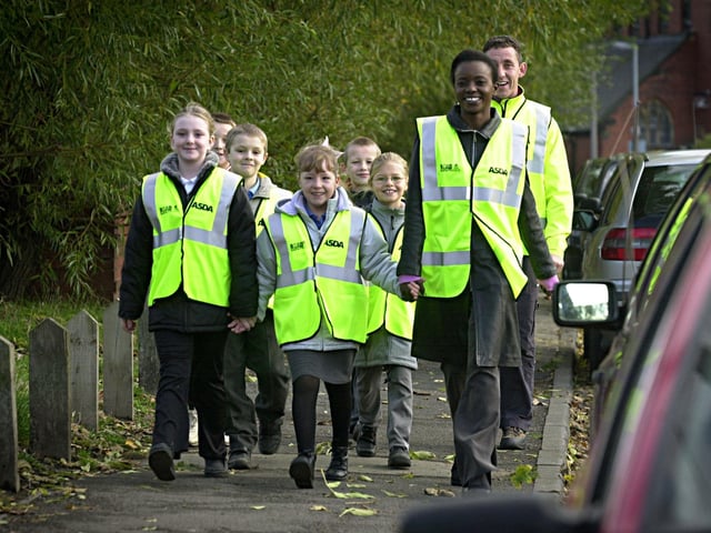November 2002 and Sara Asani leads Hugh Gaitskell Primary School pupils Demi Middleton and Rebecca Evans as part of the new Asda walking bus scheme in Beeston.
