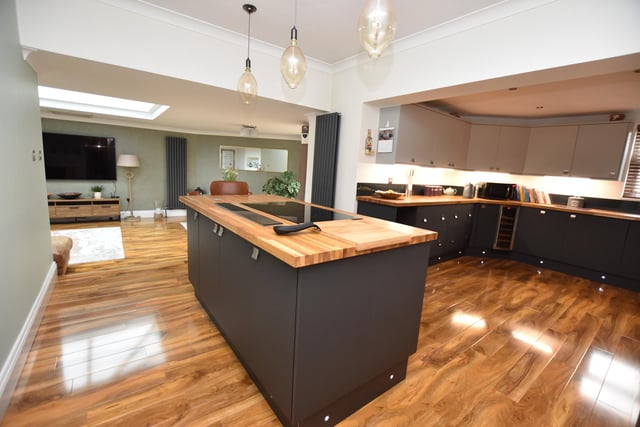 The modern fitted kitchen, being a focal feature of the property, has a quality range of wall and base units with glazed splash backs, underlighting, kick board lighting and pop-up sockets. This beautiful room has ceiling spotlights, laminate flooring, two wall mounted vertical radiators and a window to the rear.