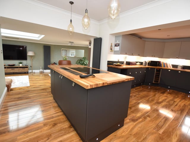 The modern fitted kitchen, being a focal feature of the property, has a quality range of wall and base units with glazed splash backs, underlighting, kick board lighting and pop-up sockets. This beautiful room has ceiling spotlights, laminate flooring, two wall mounted vertical radiators and a window to the rear.