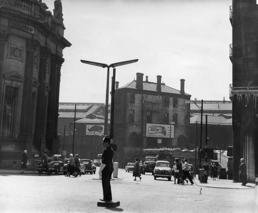 A police officer directs the traffic in Boar Lane in June 1959 at the busy junctions with Bishopgate Street where cars are visible towards the left, and Wellington Street, far right.