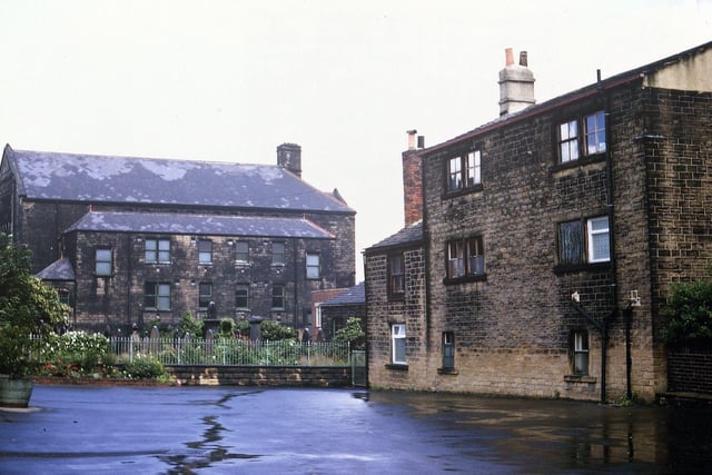 Queen Street Wesleyan Chapel Sunday School Building from the Infants' School playground pictured in  June 1966.  The overgrown nature of the Methodist churchyard behind the railings is visible. After this building was demolished for the Tesco supermarket in 1968 all the tombstones were set back to the surrounding wall and a garden of rest created. Years later the Infants School was closed and it was converted to a day nursery in the 1980s.