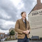 Tom Naylor-Leyland, organiser of the Malton Food Festival, in front of the large mural of a Yorkshire pudding recipe dating from the 18th century which was created a couple of years ago
