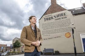 Tom Naylor-Leyland, organiser of the Malton Food Festival, in front of the large mural of a Yorkshire pudding recipe dating from the 18th century which was created a couple of years ago