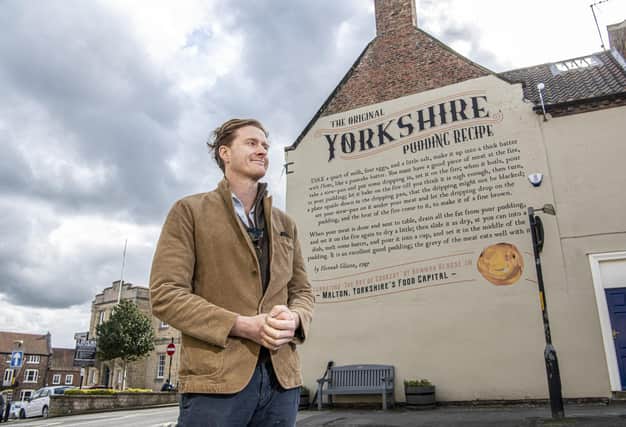 Tom Naylor-Leyland, organiser of the Malton Food Festival, in front of the large mural of a Yorkshire pudding recipe dating from the 18th century which was created a couple of years ago