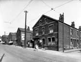 Three girls pose for the camera on Stoney Rock Lane in June 1939. From the left, the first street to intersect with Stoney Rock Lane is Back Fraser Terrace, then moving right, numbers 78/80 shop run by Leonard Smith grocers and off-licence. This shop has blinds down and John Smiths 'Magnet' ales sign. Next street is Fraser Terrace. Number 76A is Frederick Green Hairdresser, a barbers striped pole is projecting from the shop. Number 76 is the home of Michael Rogan a bus cleaner. This junction is with Back Fraser Street. Number 74 is Mrs Clara Fraser sweet shop, the name 'Nixon' is above the shop window.