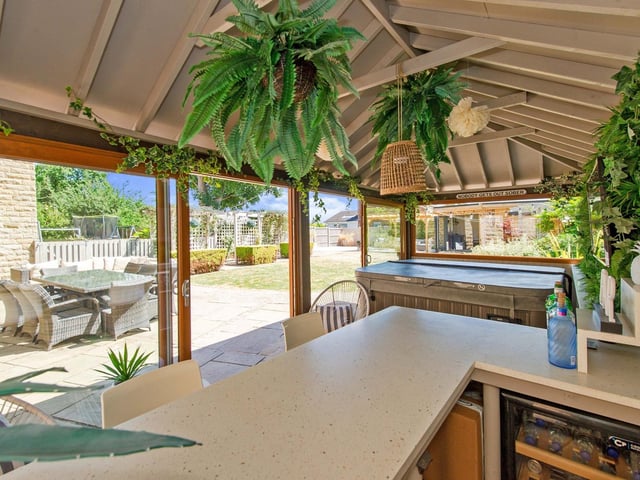 A roomy summer house adjacent to the Indian stone patio in the rear garden.