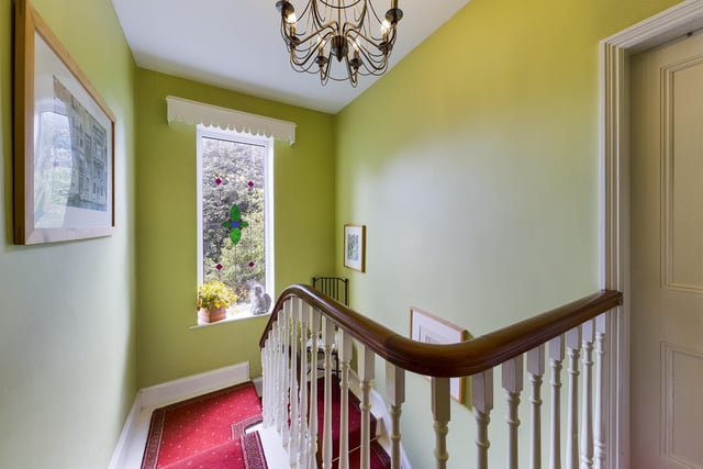 An original spindle staircase and gallery landing lit by a stained glass window.