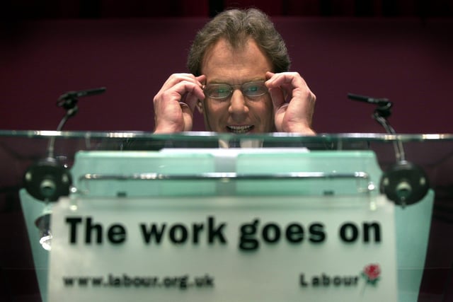 Prime Minister Tony Blair puts on his glasses before addressing business leaders at the West Yorkshire Playhouse in  May 2001.