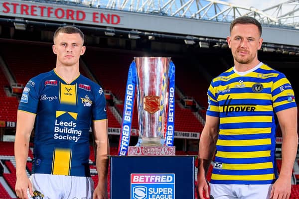 Leeds Rhinos' Ash Handley and Ben Currie, of Warrington Wolves, with the Betfred Super League trophy at Old Trafford. Picture by Allan McKenzie/SWpix.com.