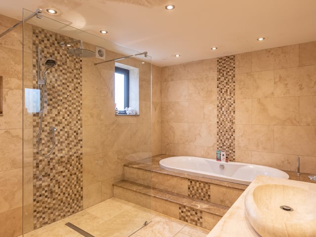 This swish, fully tiled bathroom is one of three within the house.