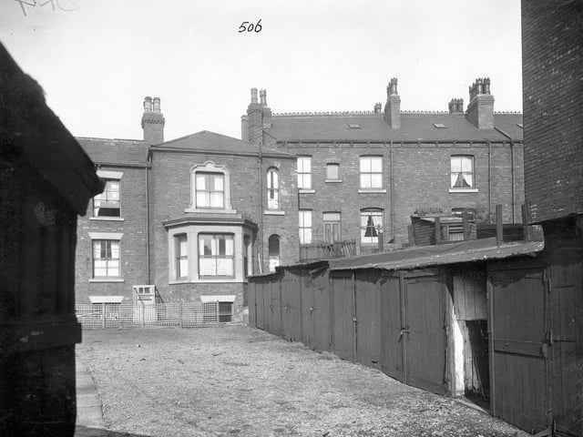 Back view of houses on Stoney Rock Lane. The houses have sash windows. A row of lock up sheds is in the foreground. Pictured in September 1935.
