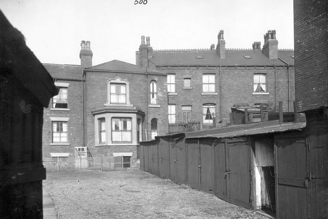 Back view of houses on Stoney Rock Lane. The houses have sash windows. A row of lock up sheds is in the foreground. Pictured in September 1935.