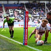 Adam Keighran gets past Ryan Hall to score for Wigan Warriors against Leeds Rhinos. Picture by Olly Hassell/SWpix.com.