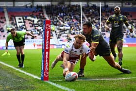 Adam Keighran gets past Ryan Hall to score for Wigan Warriors against Leeds Rhinos. Picture by Olly Hassell/SWpix.com.