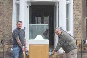 Glasshaus workshop manager Matthew Gray (left) delivers the display case to heritage trust archivist Andrew Sefton at Burnby Hall.