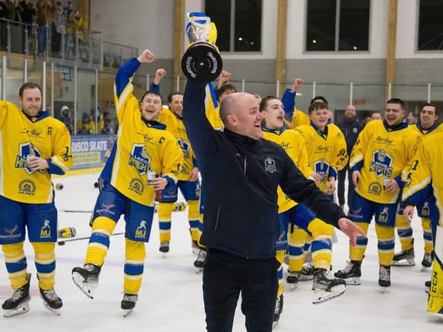 LEADING MAN: Head coach Ryan Aldridge holds the NIHL National league trophy aloft at Elland Road Ice Arena on Sunday night as his Leeds Knights' players watch on, having won the crown for the second year running. Picture: Jacob Lowe/Knights Media.