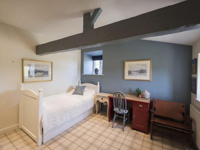 A single bedroom with space for a study area within the property.