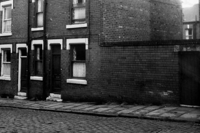 Two back-to-back terraced houses on Normanton Terrace with a yard on the right housing shared outside toilets. Pictured in June 1973.