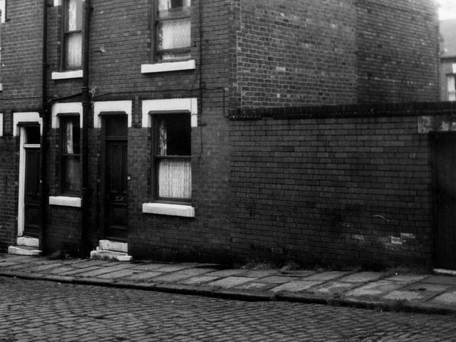 Two back-to-back terraced houses on Normanton Terrace with a yard on the right housing shared outside toilets. Pictured in June 1973.