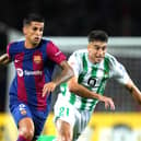 BARCELONA, SPAIN - SEPTEMBER 16: Joao Cancelo of Barcelona runs with the ball whilst under pressure from Marc Roca of Real Betis during the LaLiga EA Sports match between FC Barcelona and Real Betis at Estadi Olimpic Lluis Companys on September 16, 2023 in Barcelona, Spain. (Photo by Alex Caparros/Getty Images)