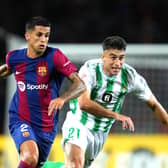 BARCELONA, SPAIN - SEPTEMBER 16: Joao Cancelo of Barcelona runs with the ball whilst under pressure from Marc Roca of Real Betis during the LaLiga EA Sports match between FC Barcelona and Real Betis at Estadi Olimpic Lluis Companys on September 16, 2023 in Barcelona, Spain. (Photo by Alex Caparros/Getty Images)